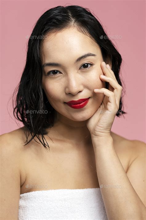 Vertical View Of The Beautiful Asian Brunette Woman With Red Lips Posing At Studio Stock Photo