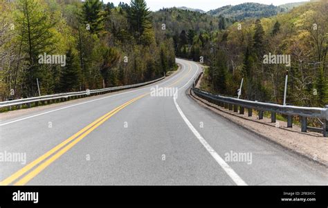 Small One Lane Road In Summer In The Countryside With A Curve At The