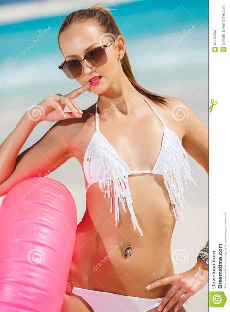 La Mujer Hermosa En Bikini Con Un Salvavidas Rosado Foto De Archivo
