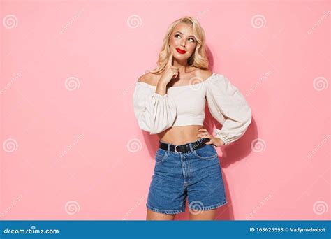 Image Of Alluring Blonde Woman With Long Curly Hair Wearing Trendy Clothes Smiling And Looking