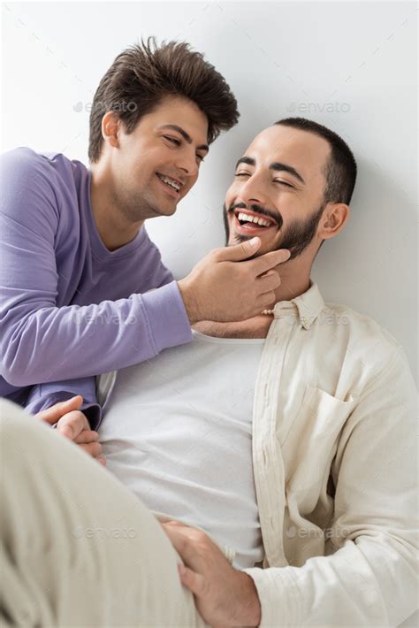 Smiling Gay Man With Braces On Teeth Touching Face Of Bearded Brunette Boyfriend With Closed