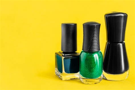 Esmalte de uñas sobre fondo amarillo Foto Premium