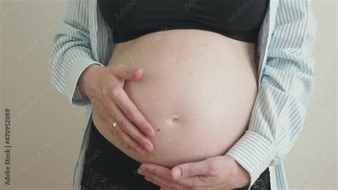 Pregnant Woman Massaging Her Belly Caring Mother Strokes A Naked Pregnant Tummy With Two Hands