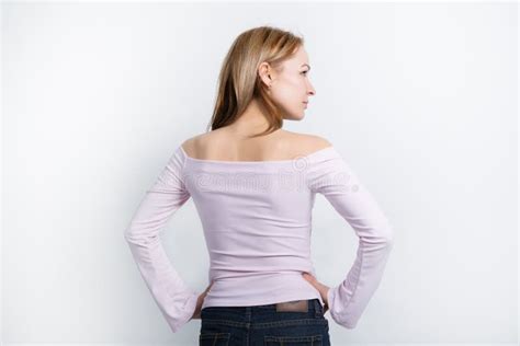 La Bella Giovane Bionda Con Le Gambe Lunghe In Una Blusa Luminosa Con Le Spalle Nude Girate A