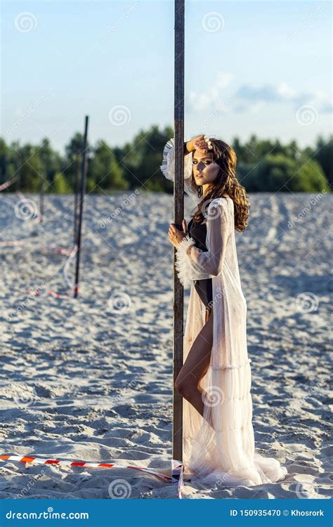 Attractive Brunette Woman In Black Body And Translucent Beach Cover Up Posing On Sandy Beach At