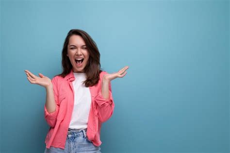 Premium Photo Happy Lucky Brunette Woman In Informal Look Rejoices On Studio Background