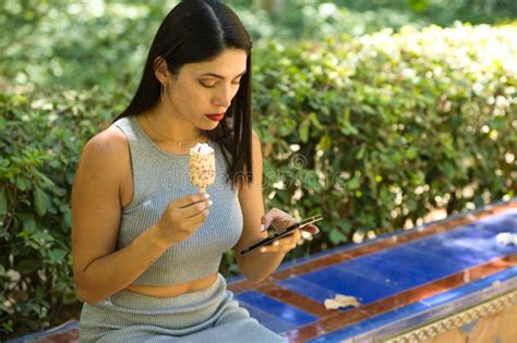 Mulher Latina Jovem E Linda Morena Consulta Seu Celular E Come Um Sorvete Refrescante Para
