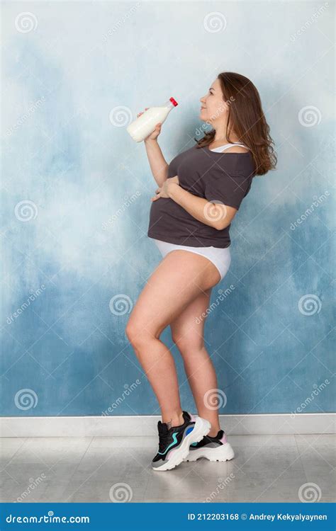 Full Length Portrait Of Pregnant Woman With Milk Bottle Female Wearing Lingerie Studio Shot