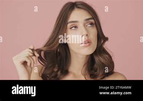 Beautiful Pensive Half Naked Woman Is Twisting A Curl Of Hair On A Finger While Thinking About