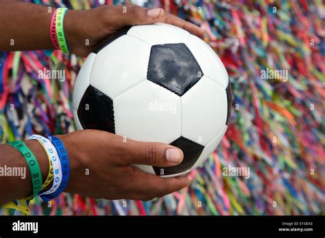 Brazilian man holding soccer ball football praying in front of ...