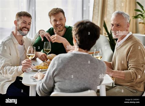 A Gay Couple Enjoys A Dinner With Parents At Home Sharing Laughter And Wine Stock Photo Alamy