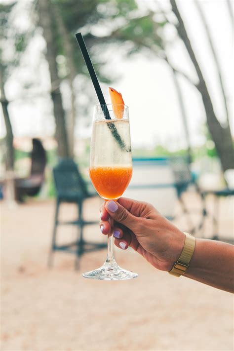 pessoa segurando uma garrafa de suco amarelo foto profissional gratuita