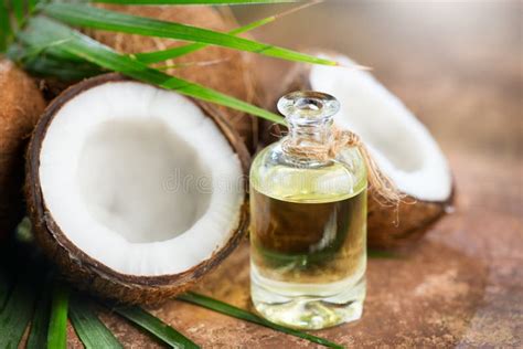 Coconut Palm Oil In A Bottle With Coconuts And Green Palm Tree Leaf On