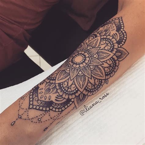A Womans Arm With A Tattoo On It That Has An Intricate Flower Design