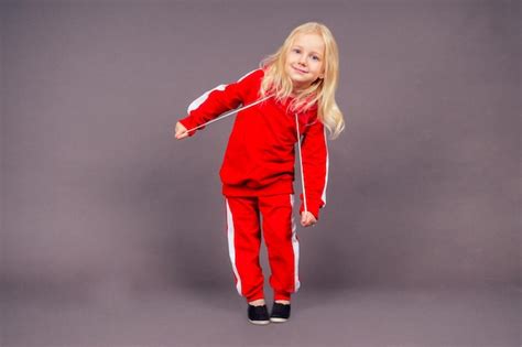 Blonde Aux Yeux Bleus Petite Fille Mod Le Dans Un Costume De Sport Rouge Qui Pose En Studio Sur