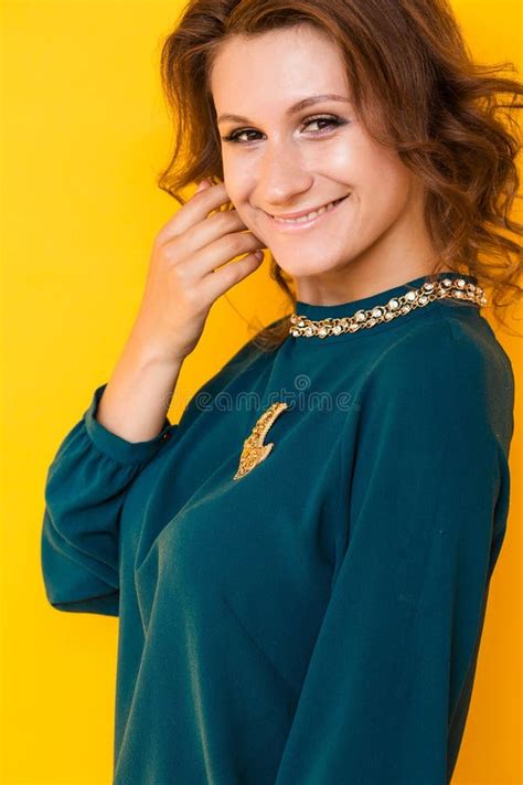 A Beautiful Brunette Woman In A Green Blouse With A Golden Brooch In The Form Of The Moon Poses