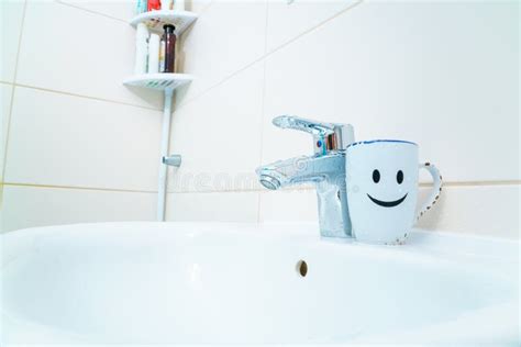 Chromed Metal Faucet For Hot And Cold Water Cup With Smile Face For Toothbrushes In A Modern