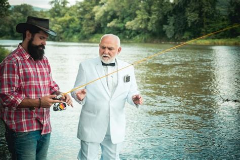 Premium Photo Father And Mature Son Fisherman Fishing With A Fishing Rod On River