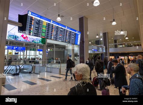 Passengers look at the arrival and departure boards at the airport ...