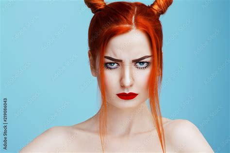 Beautiful Naked Caucasian Girl With Red Hair And Red Lips Frowns Directly Into The Camera Photo