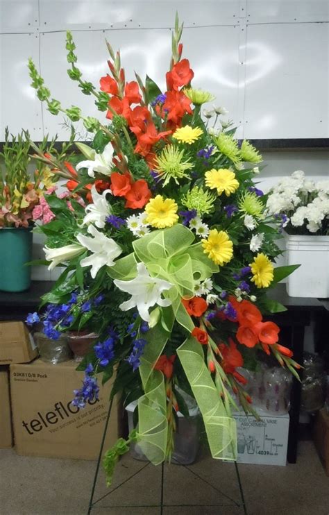 A Bouquet Of Flowers Is Sitting On A Stand In Front Of Some Other