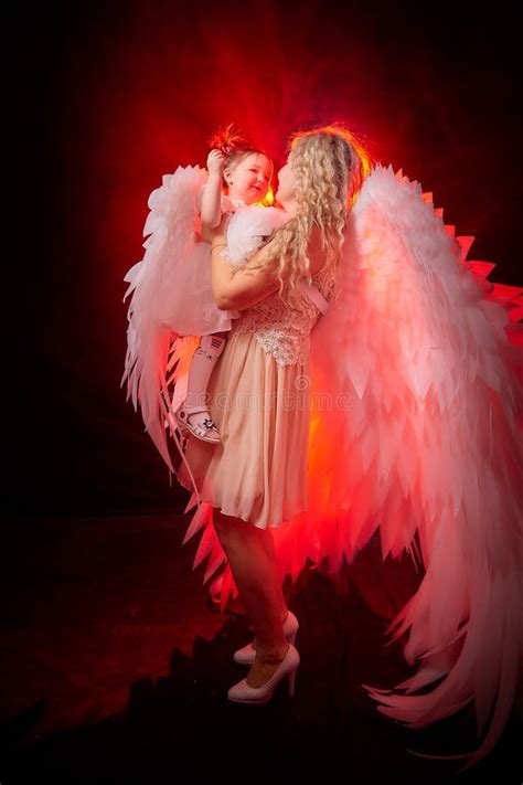 A Beautiful Blonde Girl With Curly Hair And White Wings Looks Like An Nice Angel Stock Image