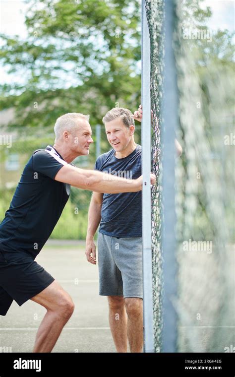 Mature Men Stretching By Fence Stock Photo Alamy