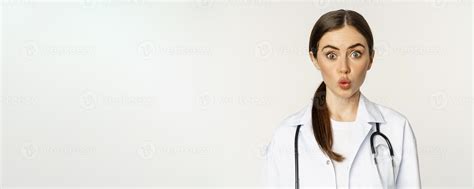 Portrait of woman doctor looking surprised, amazed, reaction of