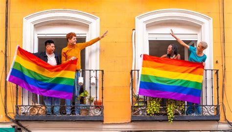 Parejas De Chicos Gay Y Chicas Lesbianas Con La Bandera Lgtb En Los Balcones En Una Fiesta En
