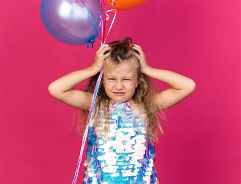Petite Fille Blonde Mécontente Mettant Les Mains Sur La Tête Tenant Des Ballons D hélium Isolés