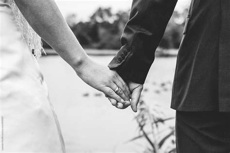 "Detail Of Bride And Groom Holding Hands With Wedding Ring In Black And ...