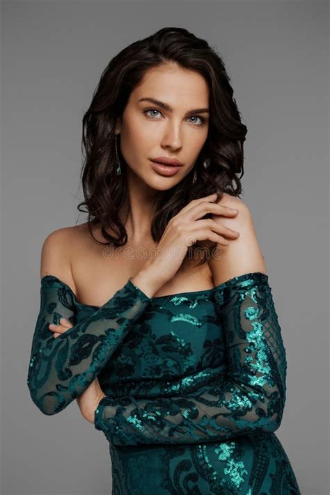 Brunette Impresionante En Un Elegante Vestido Verde De Noche Con Un Fondo Gris Imagen De Archivo