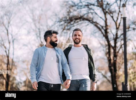Sonriente pareja gay multiétnica caminando en el parque Stock Photo Alamy