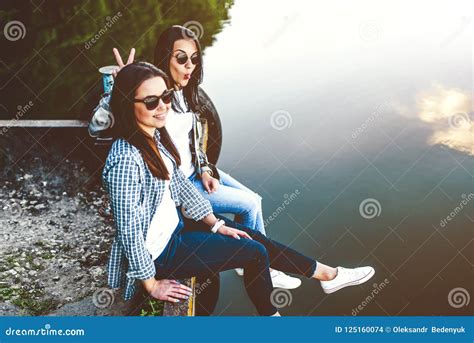 Two Cute Brunette Women Relaxing Outdoor Near Lake Stock Photo Image Of Friends Spring