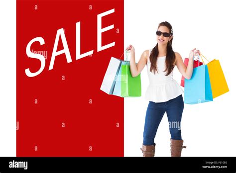 Composite Image Of Cheerful Brunette Holding Shopping Bags Stock Photo