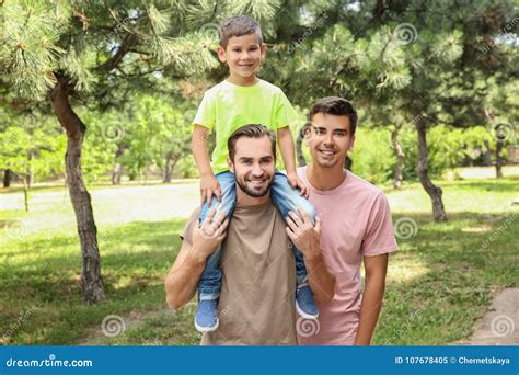 Pareja Gay Masculina Con El Hijo Adoptivo Que Se Divierte En Parque Imagen De Archivo Imagen