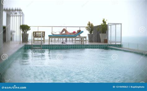 A Woman In A Pink Bikini Is Enjoying The View Of The Sea By The Pool On