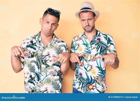 Joven Gay Pareja De Dos Hombres Con Sombrero De Verano Y Camisa Hawaiana Apuntando Hacia Abajo