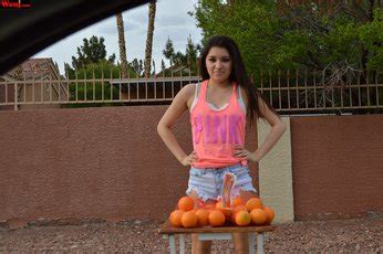 Hot Brunette Girl Selling Oranges On The Corner Of The Street Photos