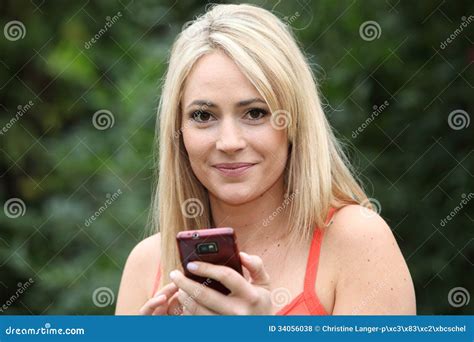 Glimlachende Blonde Vrouw Met Een Mobiele Telefoon Stock Foto Image Of Media Aantrekkelijk