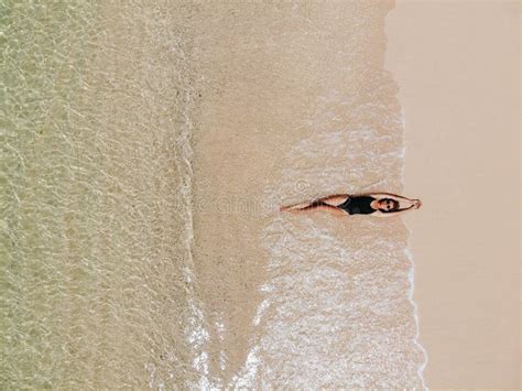 Vista Aérea De Una Joven En Bikini Negro Tumbada En Una Playa De Arena Blanca Olas Espumantes