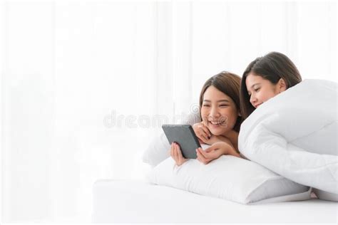 Close Up Of Lesbian Couple Embracing In The Bed Play Phone Happily Stock Photo Image Of Enjoy