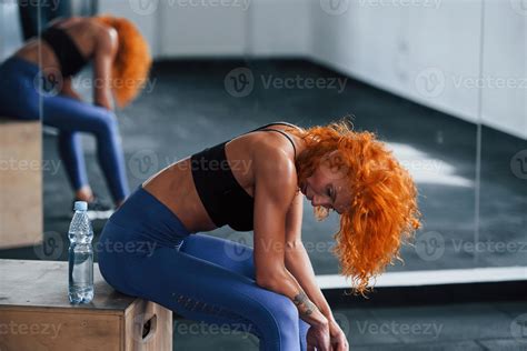 Tired, taking a break. Sporty redhead girl have fitness day in gym at