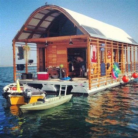 two small boats are docked in the water next to a boathouse on stilts