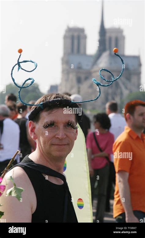 A Participant In The Annual Gay Pride Parade Marches Past Notre Dame Cathedral In Paris France