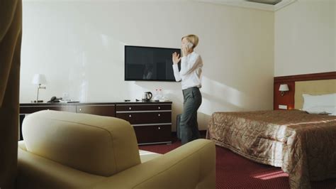Blonde Businesswoman Talking On Phone Then Taking Her Suitcase And Leaving Hotel Room At Check