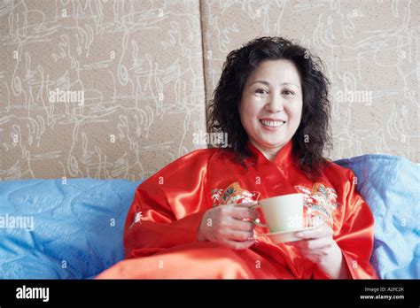 Portrait Of A Mature Woman Lying On The Bed With A Cup Of Tea Stock Photo Alamy