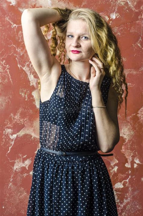 Jong Meisje Met Blonde Krullend Haar In Een Lange Kleding Met Stippen Met Teddybeer Stock Foto