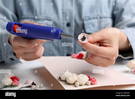 Woman Using Hot Glue Gun To Make Craft At White Table Closeup Stock