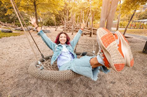 Premium Photo | Happy girl has fallen into childhood has fun and rides on a swing on the ...